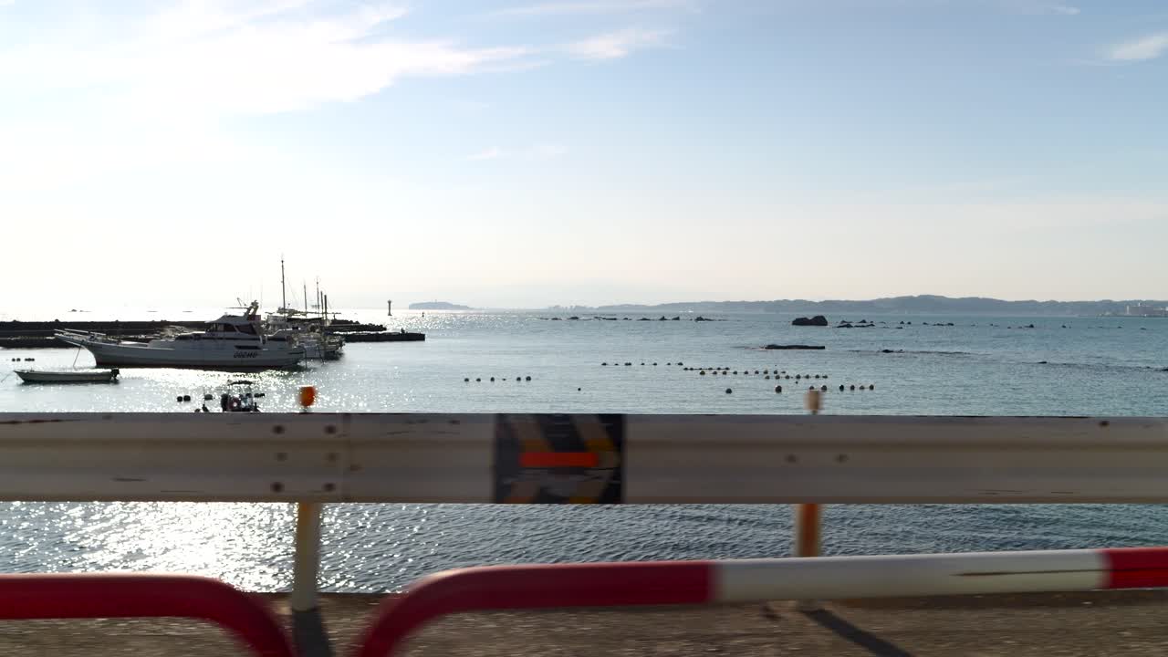 Fishing boats in a sunny bay with distant coastline