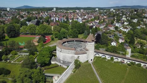 aerial orbit of munot ring-shaped fort on top of verdant hill in picturesque schaffhausen village surrounded by trees, switzerland