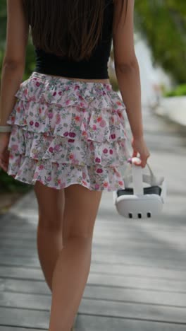 mujer con falda floral y auriculares vr caminando