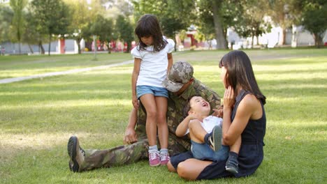 Man-wearing-military-uniform-enjoying-leisure-time-with-kids-and-wife