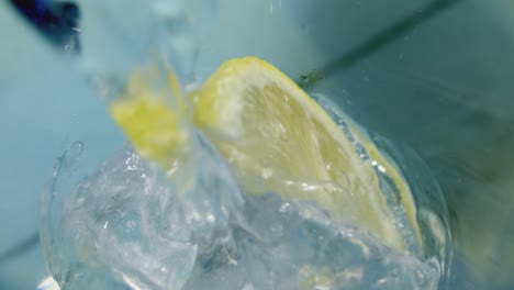 crystal clear water poured over ice and lemon wedge