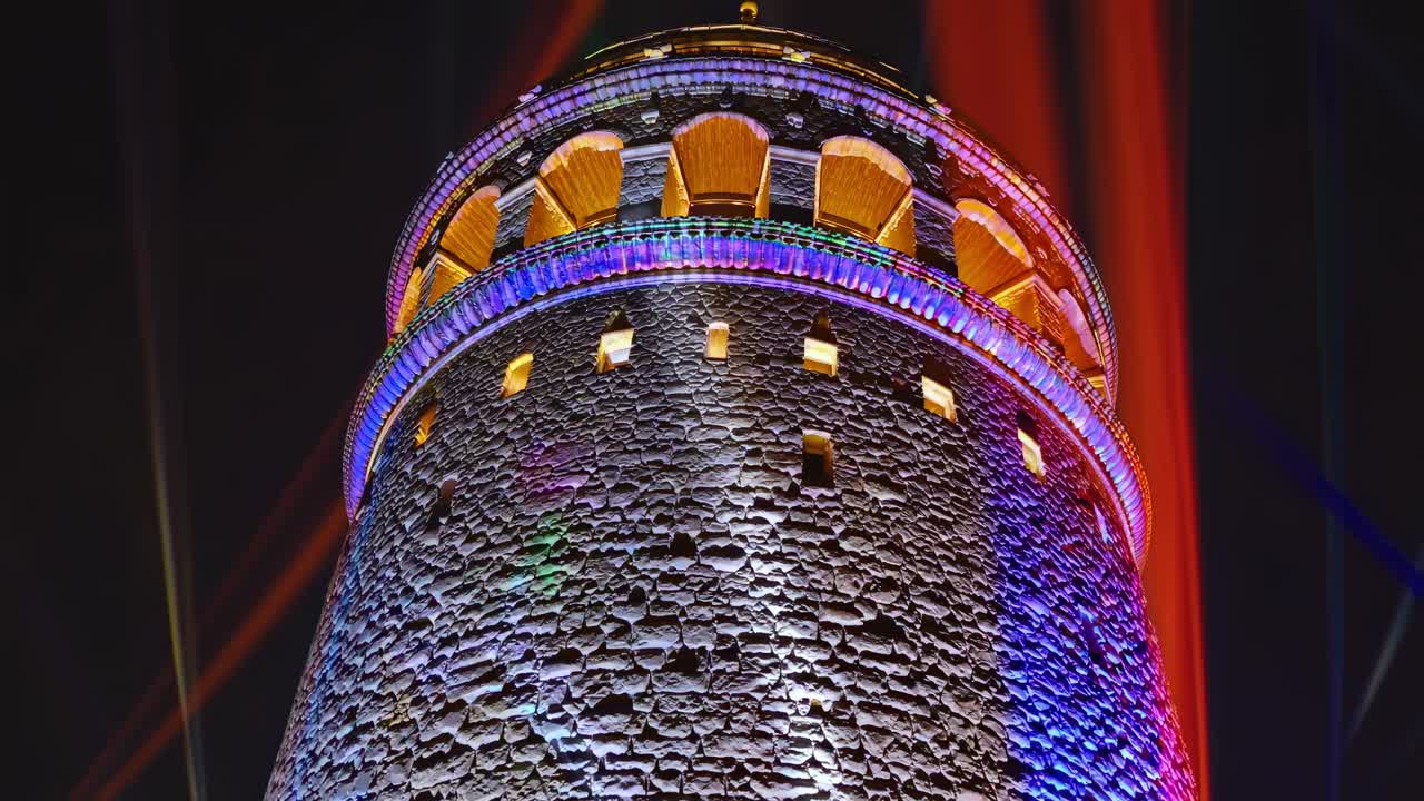 Powerful light beams illuminating the ancient Galata Tower in Istanbul, Turkey, create a magical atmosphere, transforming the night into a vibrant spectacle of color and history