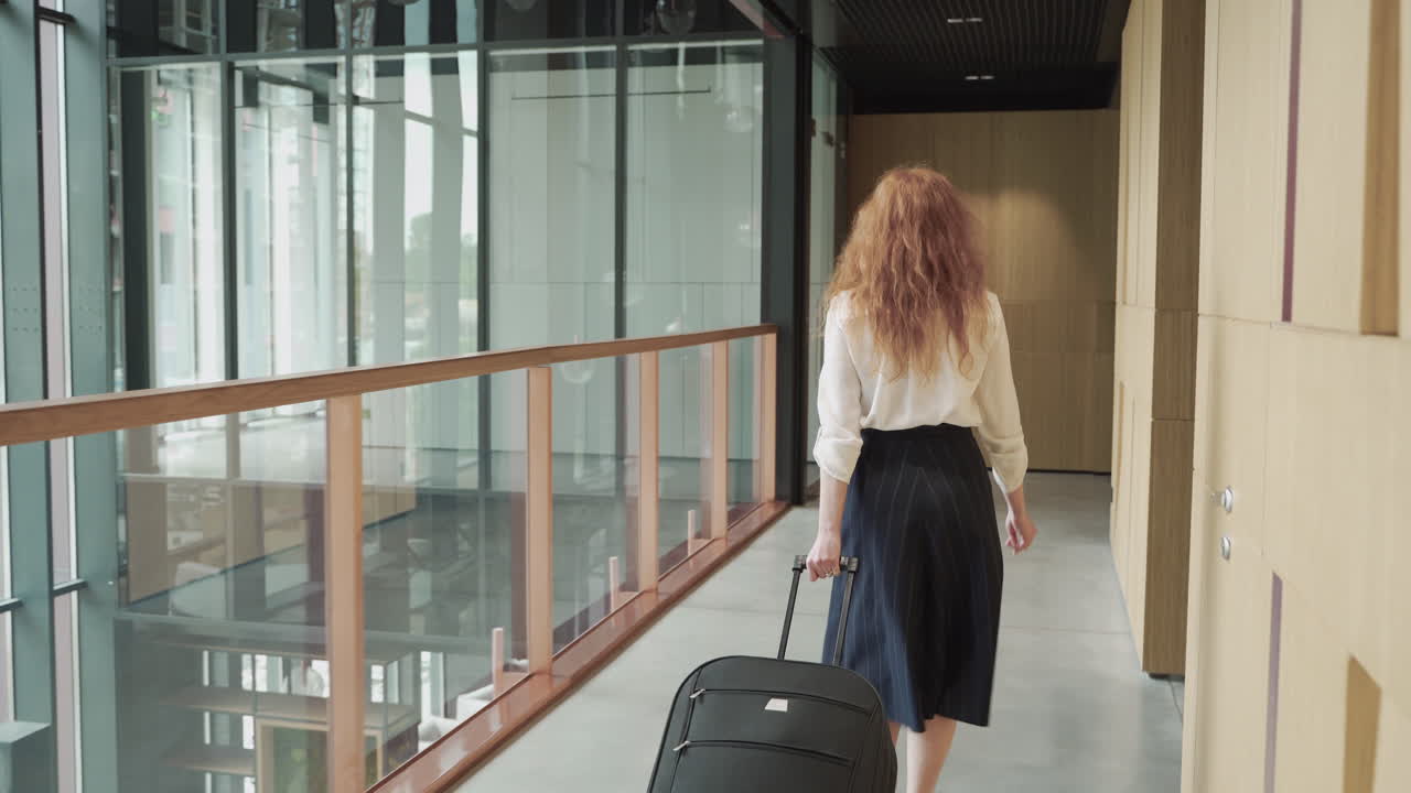 una mujer de negocios irreconocible camina hacia atrás con un tranvía. ella está en camino a un importante viaje de negocios.