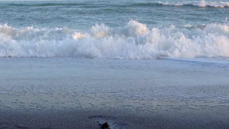 waves crushing towards camera, close up ground level view