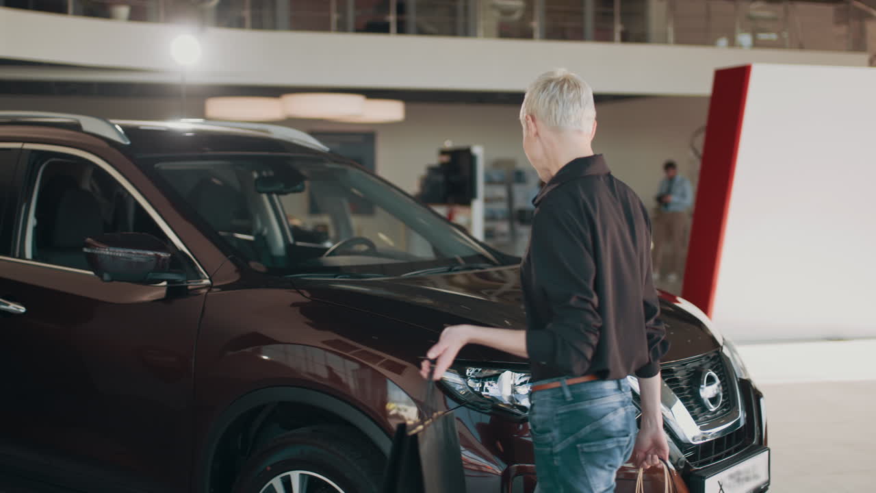 mujer comprando un coche en una sala de exposiciones