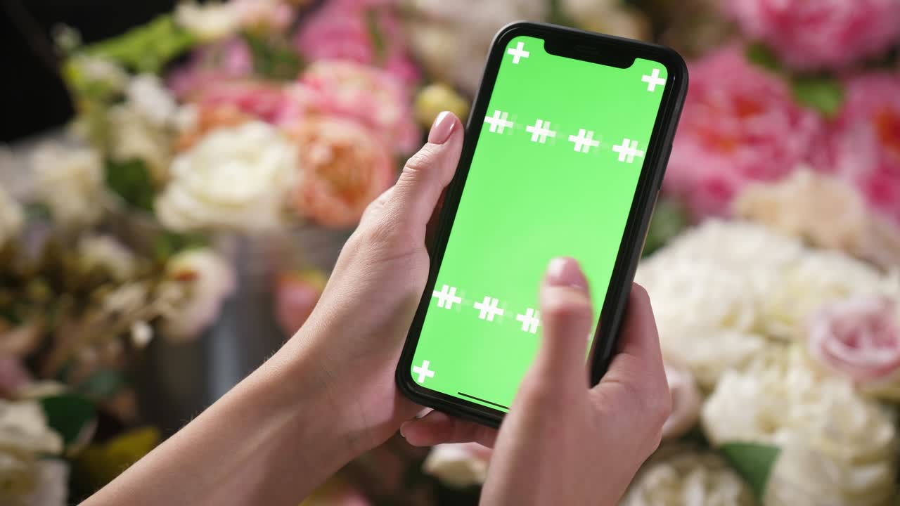 niña sostiene un teléfono inteligente iphone en las manos con una pantalla clave de croma de maqueta verde para el anuncio
