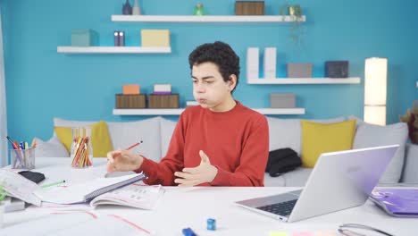 Male-student-bored-and-angry-with-distance-education-at-home.