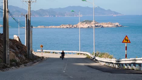 cafe racer motorbike driving up seaside road in vietnam, going surfing with the board and kite