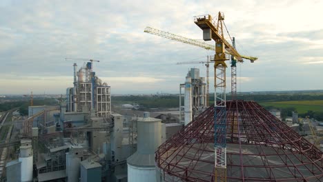 aerial view of cement factory with high concrete plant structure and tower crane at industrial production area. manufacture and global industry concept