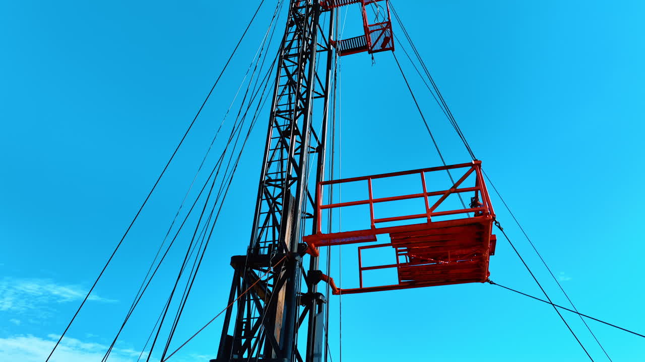 Approaching the bridge at the tower for drilling oil. Flying up to the top of the derrick for producing the natural resources.