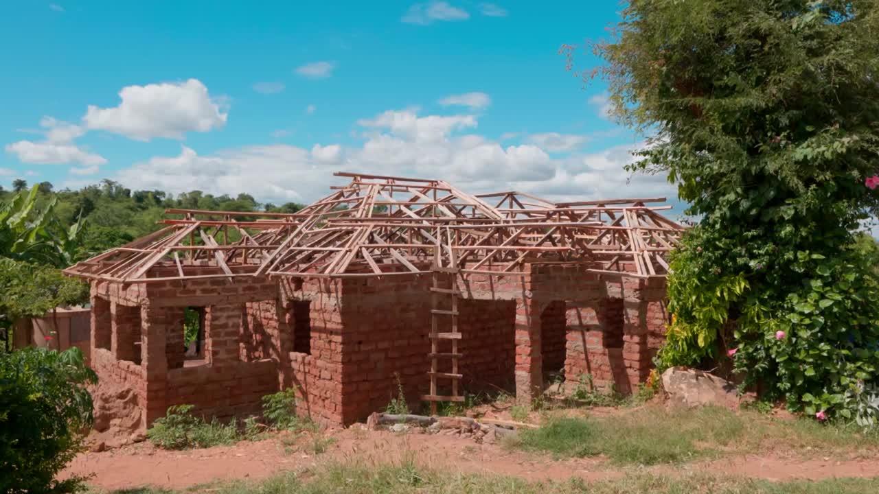 casa de ladrillo en construcción con estructura de techo de madera en un día soleado