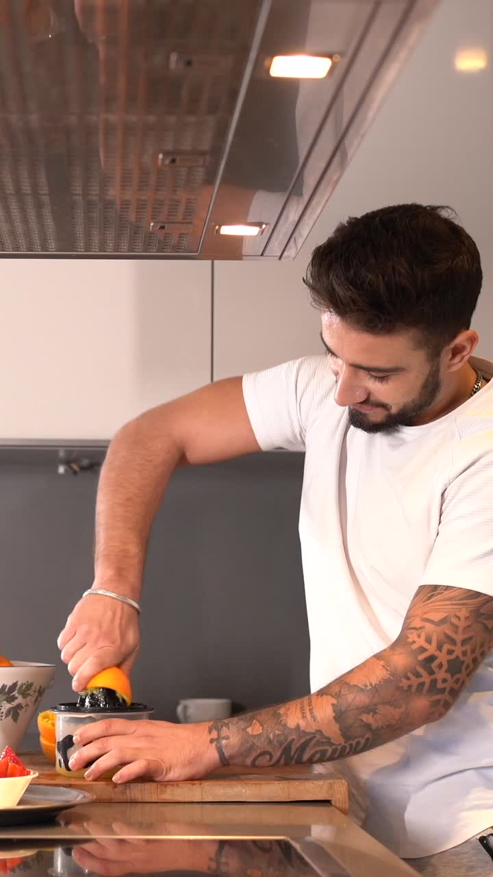 Man Making Fresh Orange Juice in Kitchen