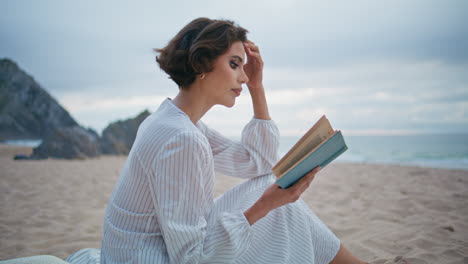 outdoor woman enjoy book at cloudy seashore closeup. romantic lady rest beach