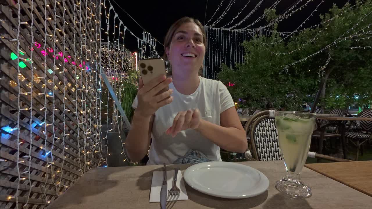 Happy Woman Receiving a Mojito Cocktail at a Night Cafe