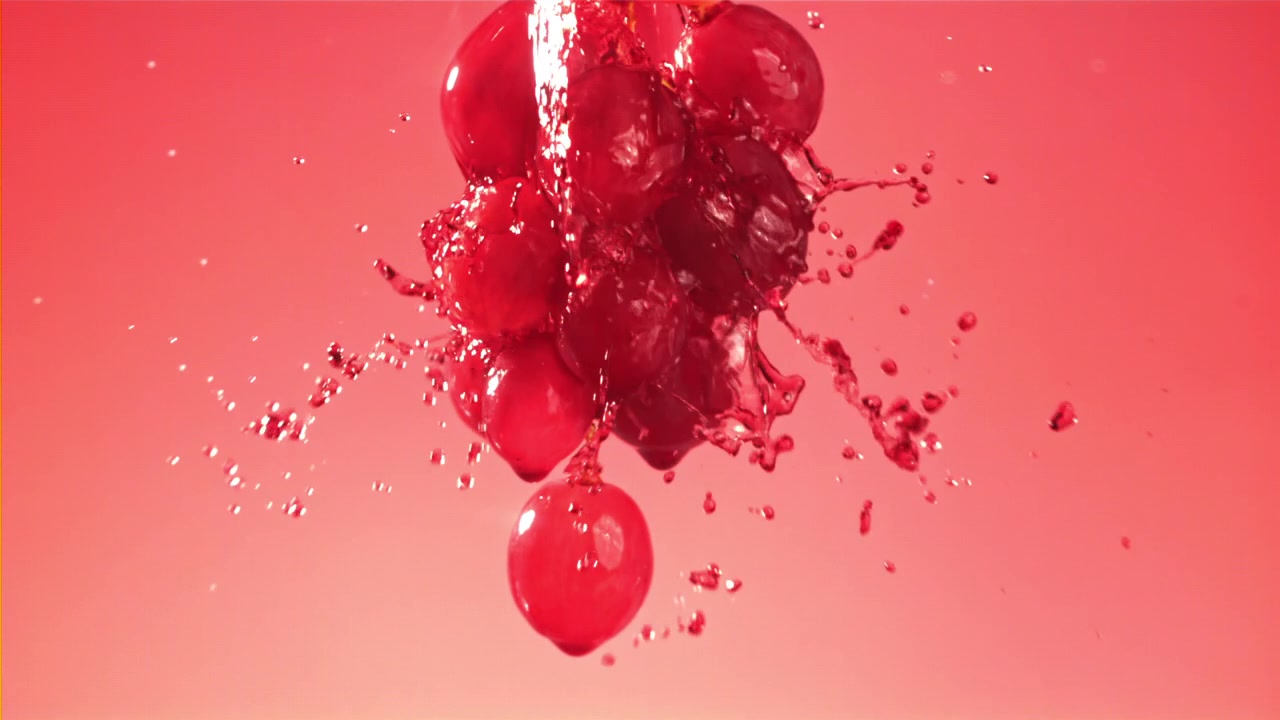 Fresh Red Grapes Splashing with Liquid in Slow Motion
