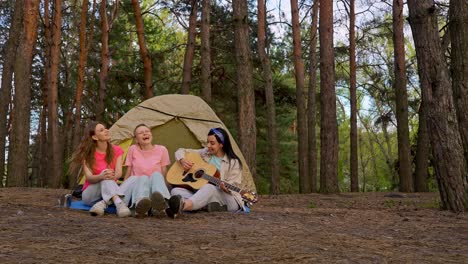 friends enjoying music in a forest campground