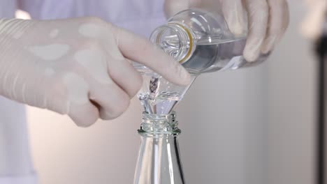 lab experiment with liquids, pouring liquids into a bottle using a funnel