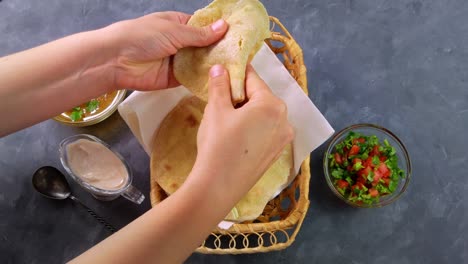 homemade corn flatbread female hand cilantro greens tomato salsa. handmade mexican tortillas vegetable salad traditional indian punjabi makki ki roti bread plate 4k wheat flour dough authentic cuisine