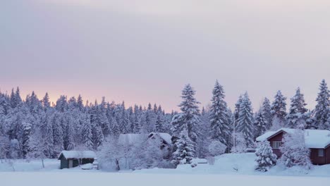 Cozy-Cabins-At-Sunset-Surrounded-By-Snow-covered-Forest-In-Winter-In-Indre-Fose,-Trondelag,-Norway