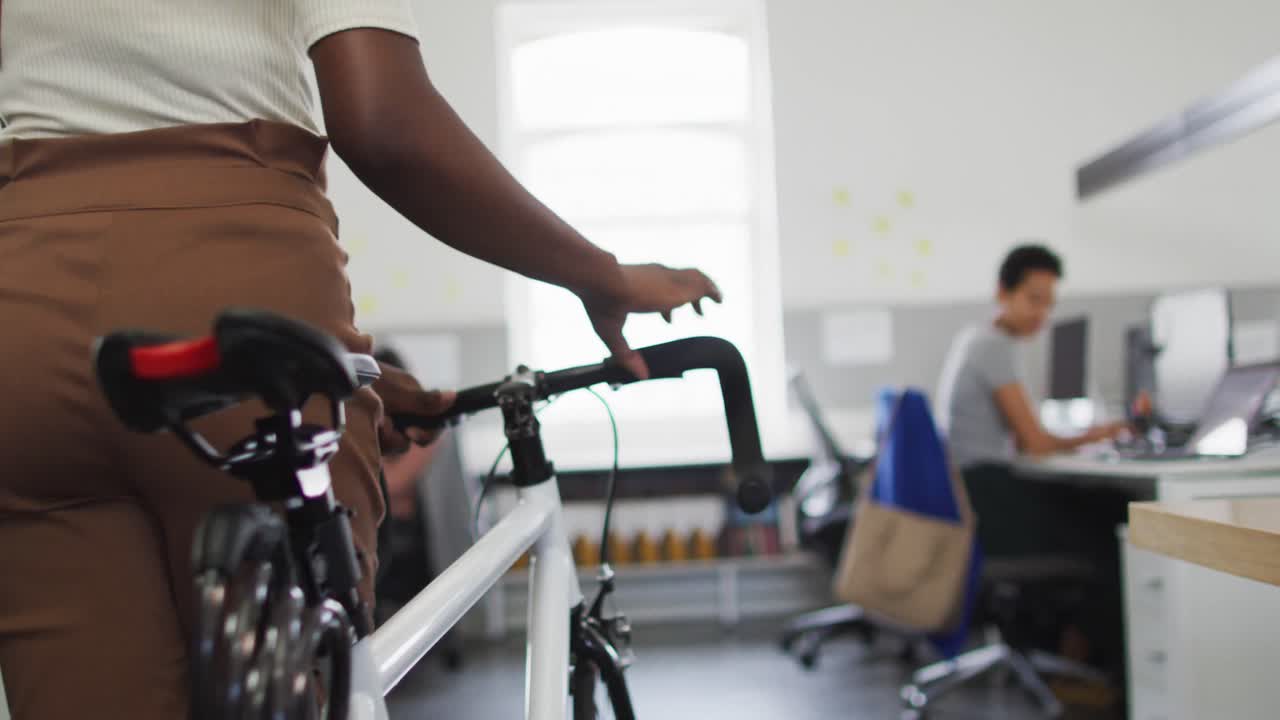 자전거 를 타고 사무실 에 도착 하는 아프리카계 미국인 사업가 의 중간 부분