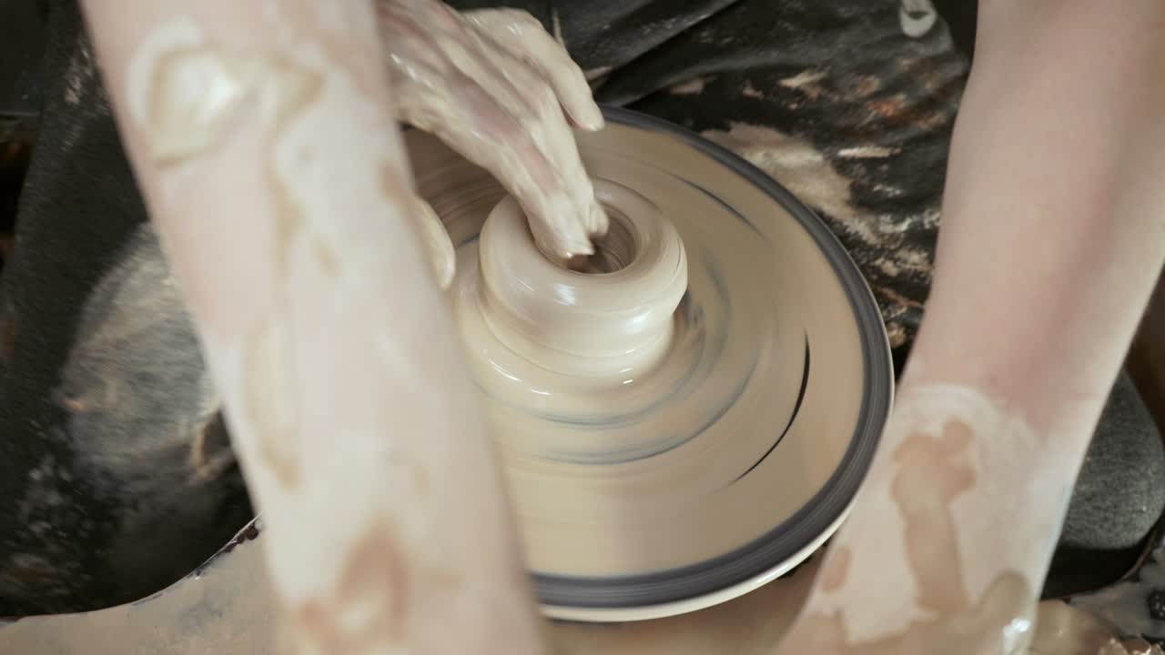 un ceramista insegna a una donna a fare piatti d'argilla. un uomo prende le mani di una donna