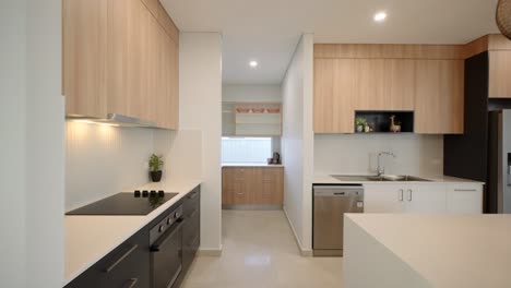 interior de la cocina contemporánea en una casa de exhibición que conduce a la despensa de un mayordomo con gabinetes elegantes y diseño minimalista