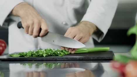 chef hands cutting celeriac at kitchen. closeup chef hands cooking greenery.