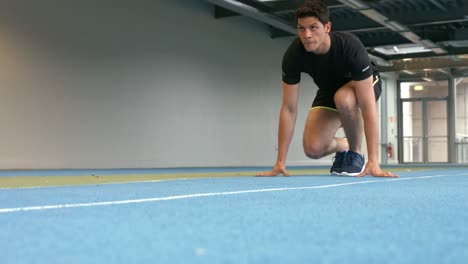 hombre compitiendo en una pista cubierta