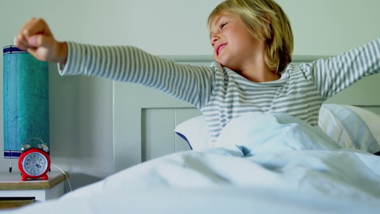 Ragazzo che sbadiglia sul letto nella camera da letto a casa 4k
