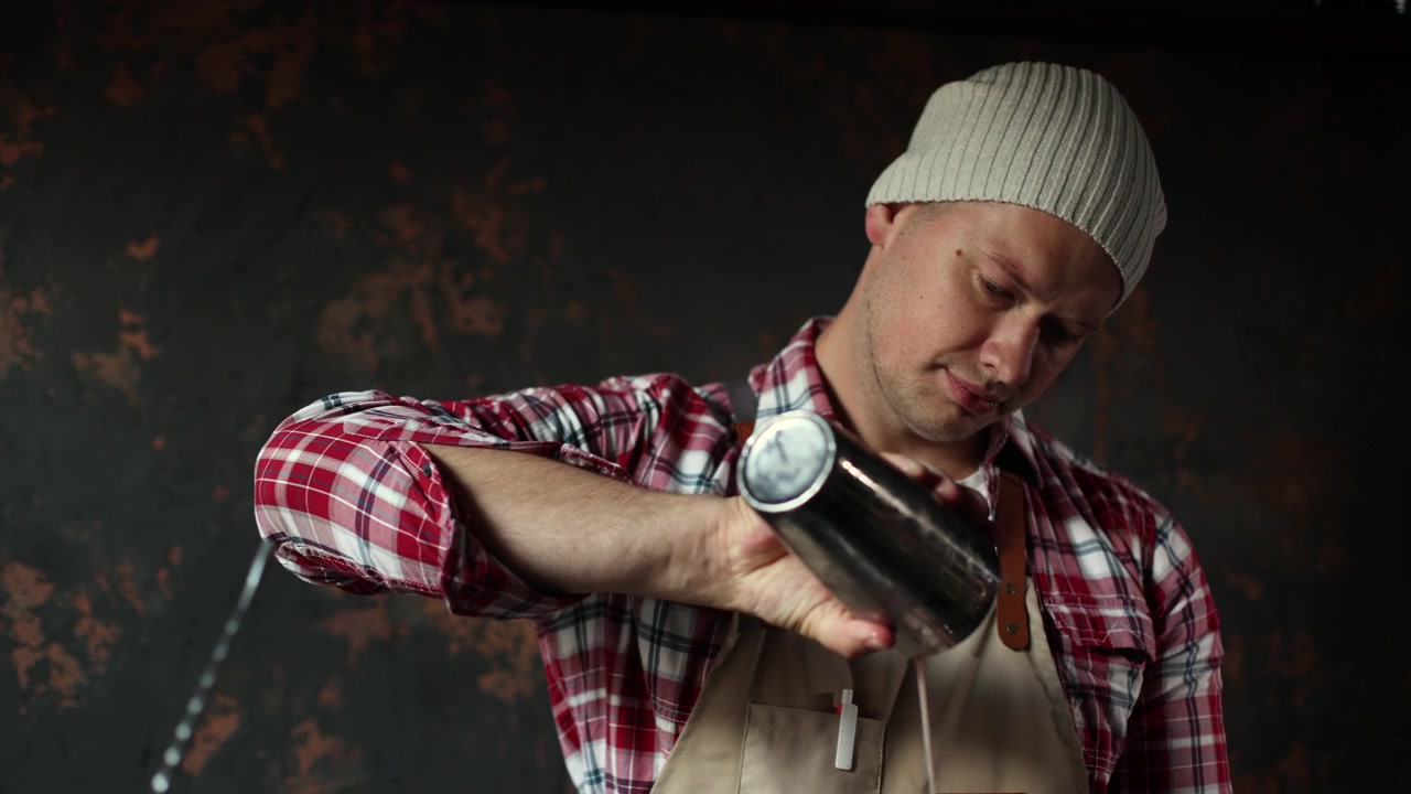 Barman professionnel secouant et versant un cocktail