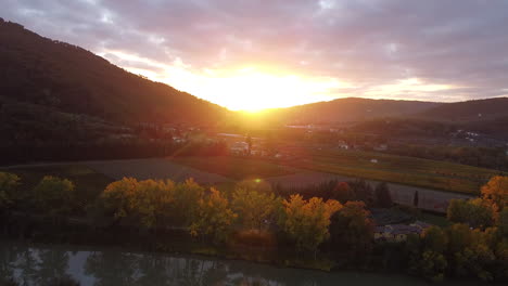 approaching aerial overview of tuscany province, italian countryside green vineyard-covered hills sunset on a cloudy day