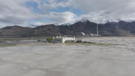 Wide-aerial-view-of-the-Great-Salt-Lake,-Utah-with-large-copper-mine-smelter-and-mountain-range-in-background