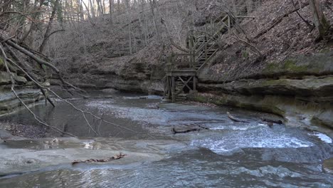 Wooden-stairs-in-forestry-slope-to-reach-forest-river-waterfalls