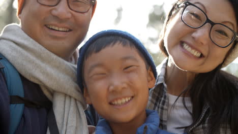 handheld close up of asian family of four in a forest