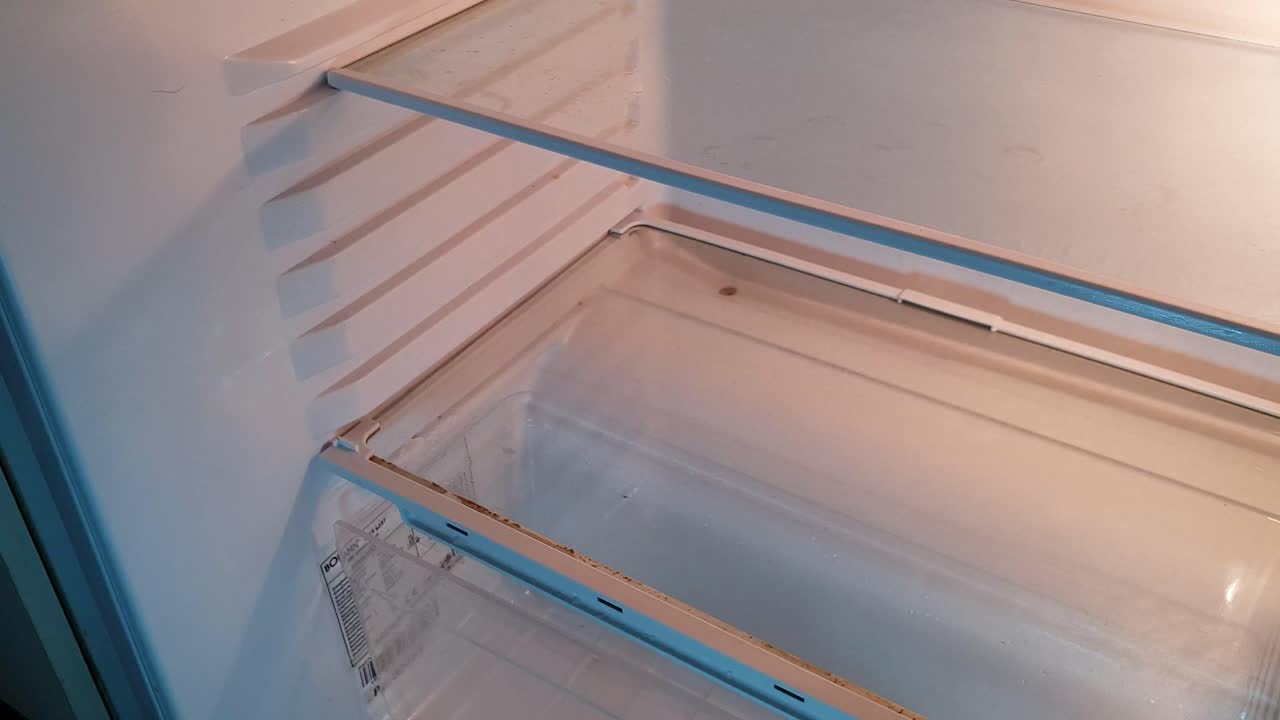 보라색 고무장갑을 끼고 빈 청소 냉장고의 보드를 정리하고 부착합니다.