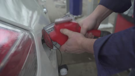 close-up of a gas tank on a car being filled with gas