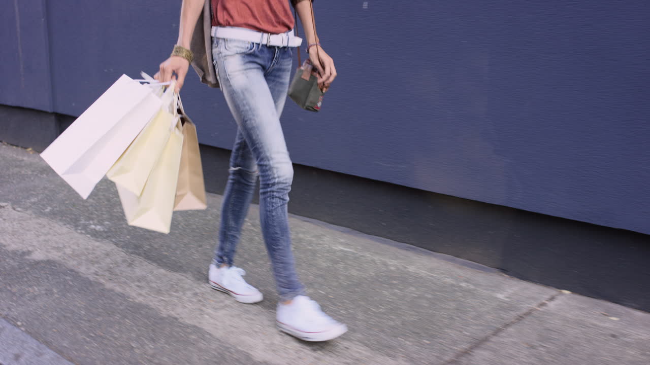 hermosa mujer llevando bolsas de compras caminando por la ciudad