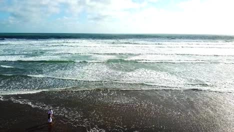 Lovers-dancing-on-the-beach,-Bethells-beach-in-New-Zealand