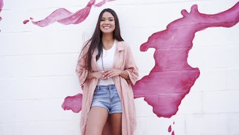 stylish woman in a pink coat and denim shorts