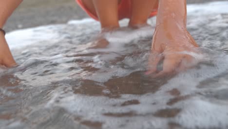 close-up of a little girl releasing a baby sea turtle into the sea