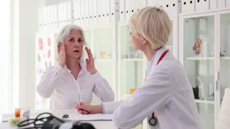 doctor consults with a senior patient experiencing discomfort