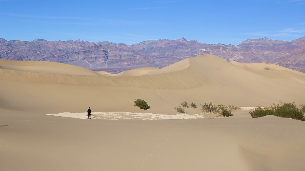 사막의 거대한 모래 언덕을 혼자 걷는 외로운 사람