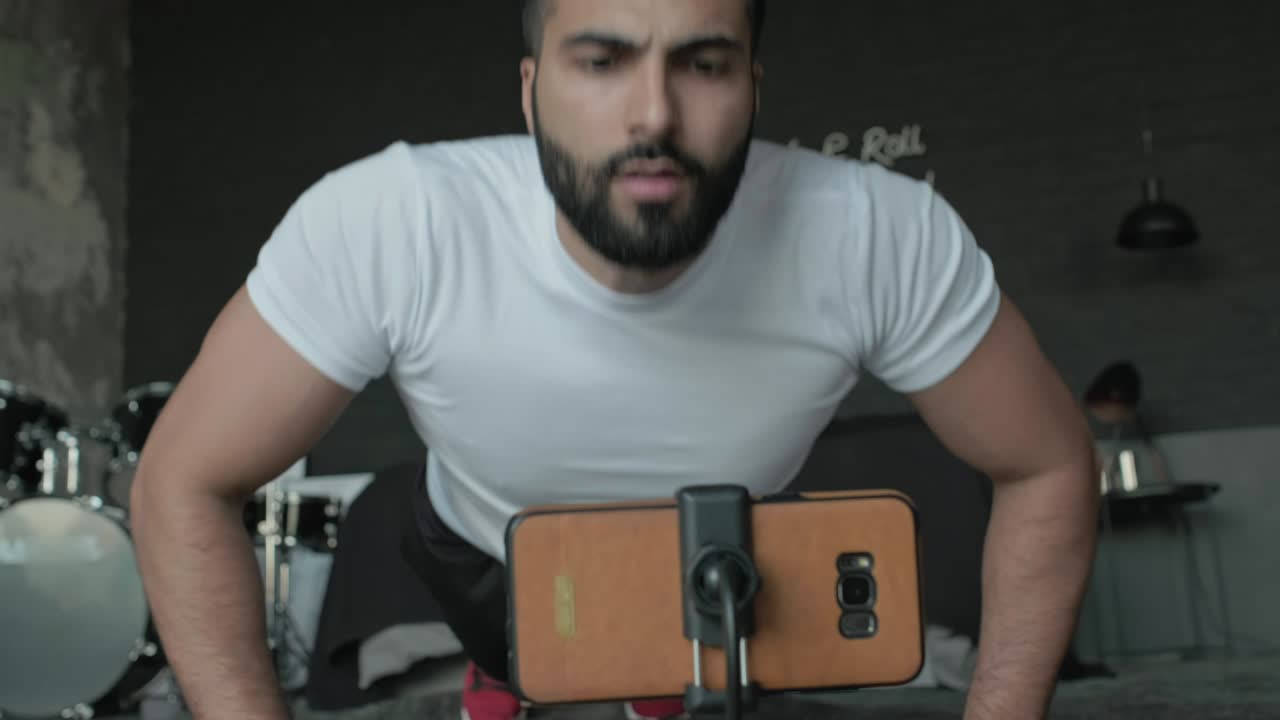 joven haciendo ejercicios en el estudio de música y lo dispara en el teléfono.