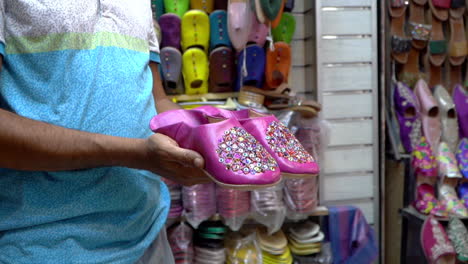 Stylish-pink-belgha-leather-shoes-showcasing-Moroccan-craftsmanship-in-the-vibrant-old-medina-market-of-Marrakech