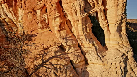 sweeping drone shot capturing a hidden rock arch kissed by the sunrise near kanab, utah.