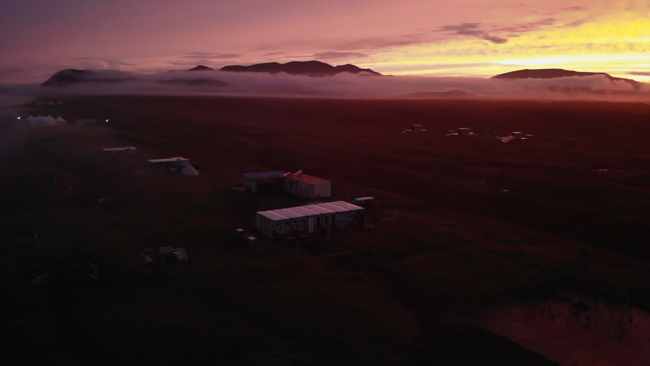 Sunset over rural landscape with mountains and fog