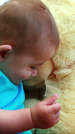 un niño lindo jugando con un oso de peluche
