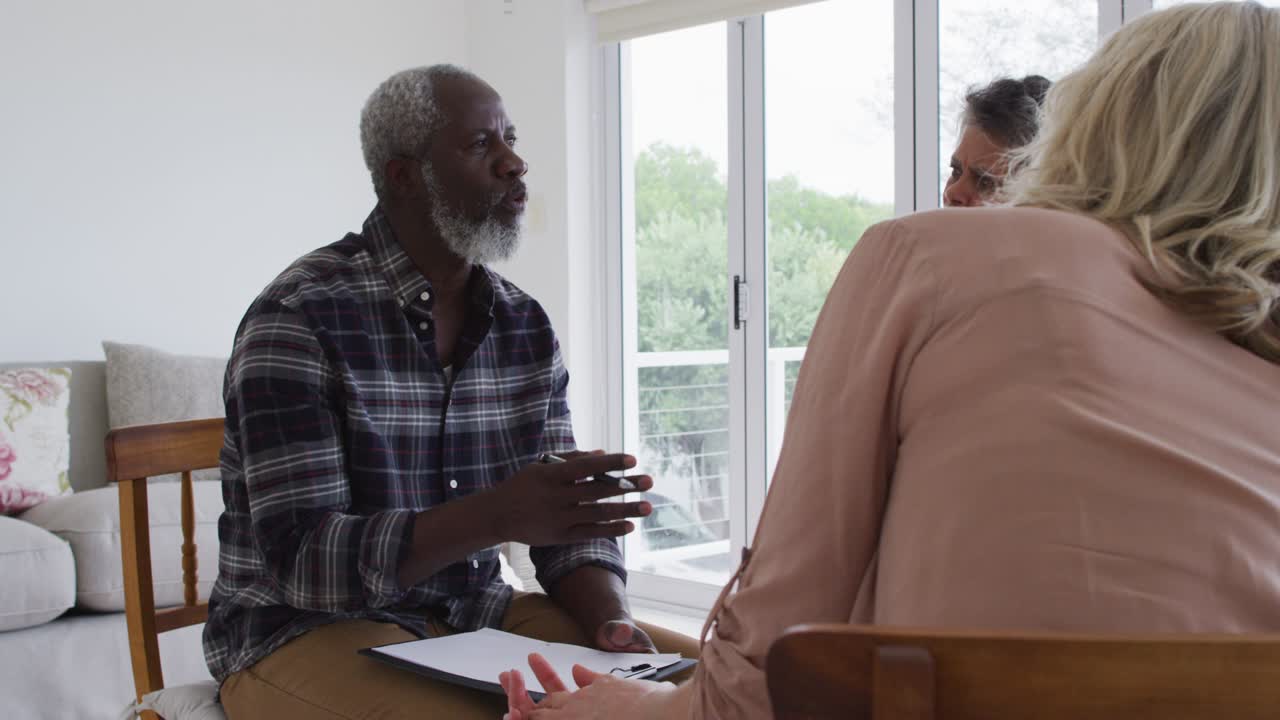 dos parejas de ancianos diversos sentados en círculo teniendo una conversación de terapia en casa
