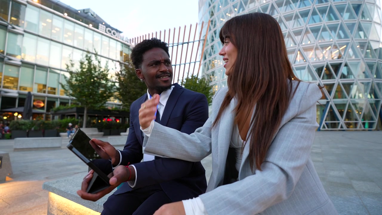 Business Colleagues Discussing Work on Tablet Outdoors