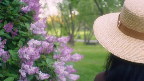 Black-Woman-walking-touching-flowers-lilacs-wide-pan-close-up